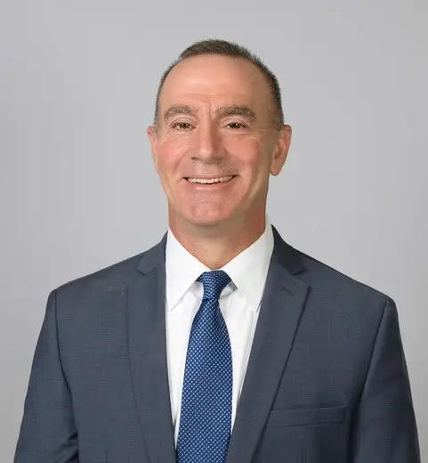 professional business headshot photo of a smiling man with short hair in a grey suit, white dress shirt, and a blue dotted tie. New Jersey Crash reconstructionist Accident investigator Accident investigations Accident expert Fleet consultant Fleet consulting Trucking Safety consulting Driver safety training